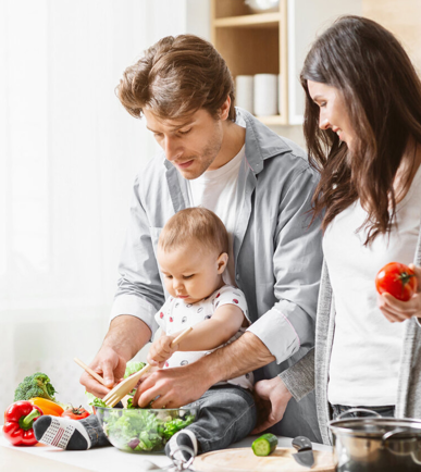 Familie mit Neugeborenem während der Elternzeit in der Küche - Familienzeit-Initiative Schweiz
